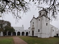Large white church with connected historical structures.