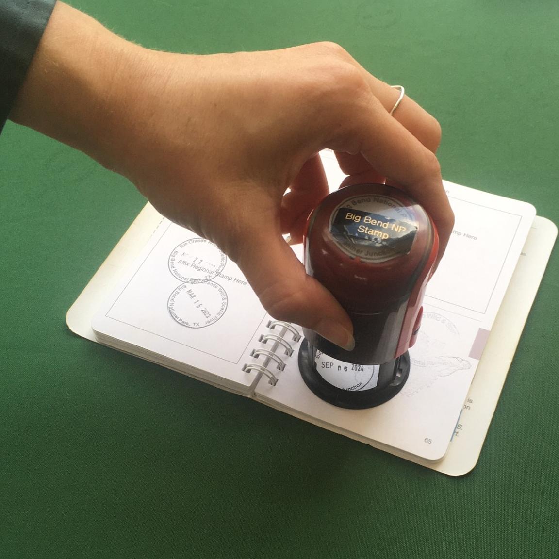 Park visitor stamping their NPS Passport book