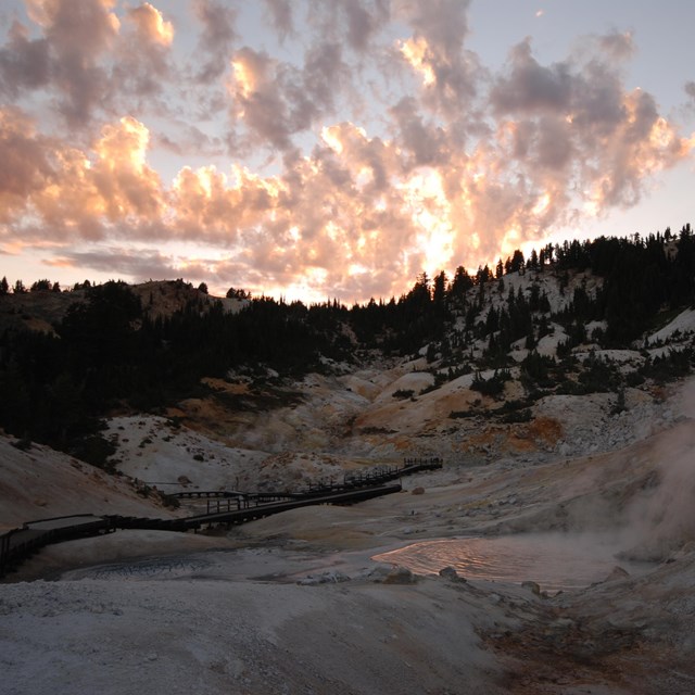 Steam rises over Bumpass Hell hydrothermal area at sunset
