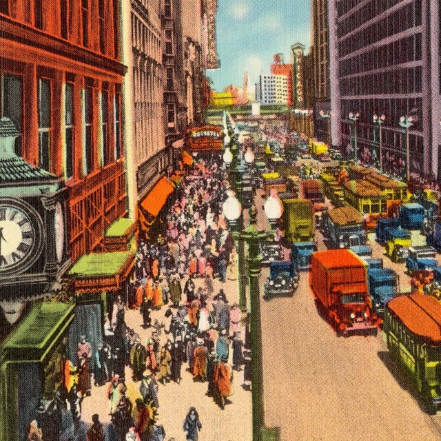 Colorized image of a busy city street flanked by tall buildings. A clock tower is in the foreground.