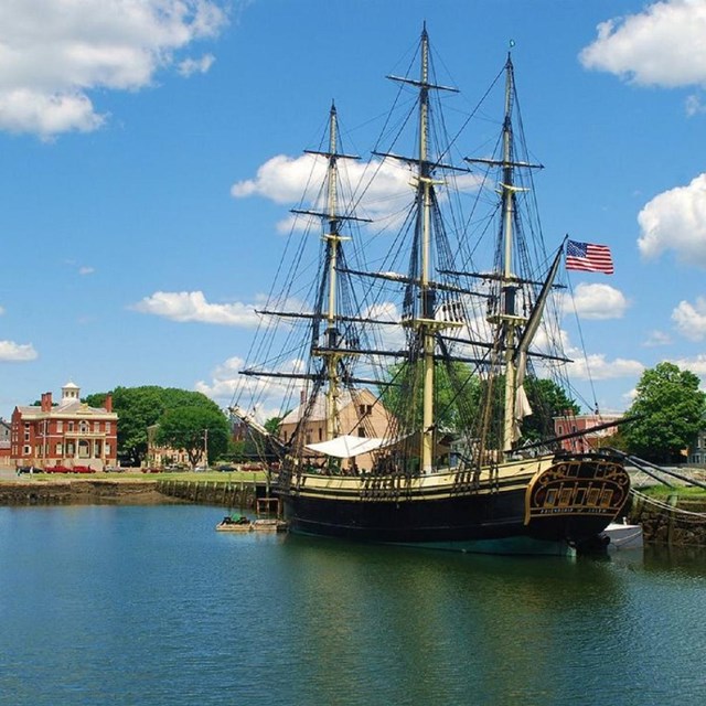 The tallship Friendship of Salem sits along historic Derby Wharf in front of the 1819 Custom House