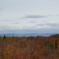 View from ridgetop with trees in fall foliage, Lake Superior, and the Canadian shoreline. 