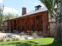 A large log structure with picnic area in front