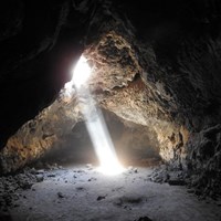 A beam of light shines into the lava tube