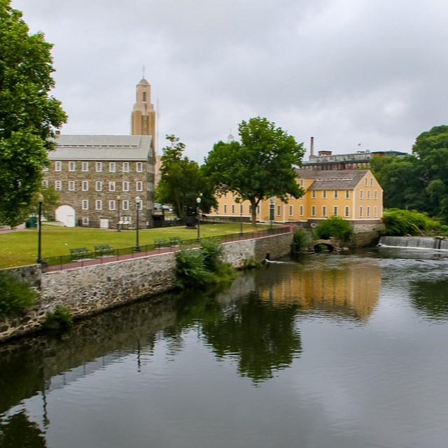 View from across the water of Slater Mill and Wilkinson Mill