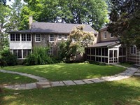 A two-story stucco cottage with screened porches.
