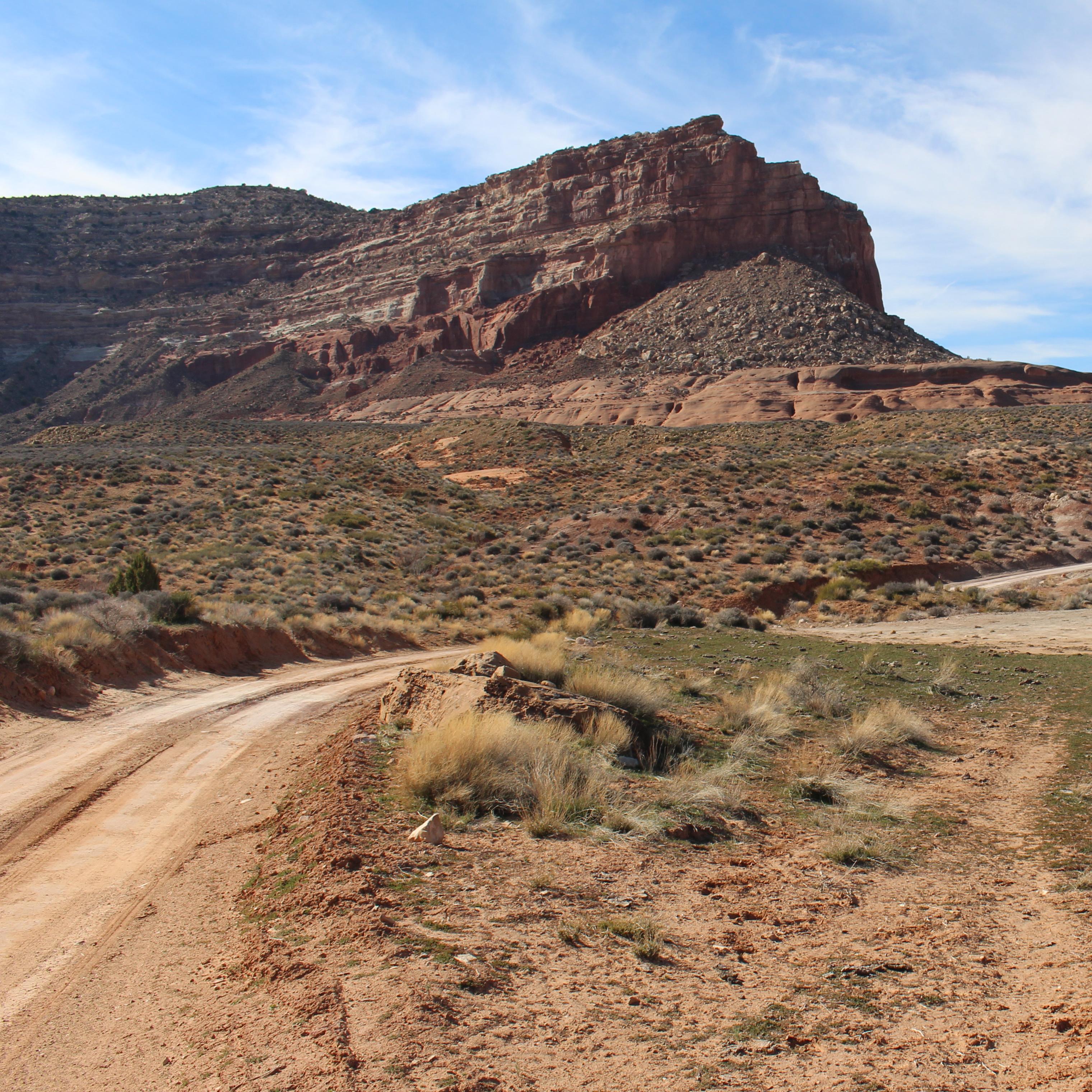 A dirt road with large sandstone boulder