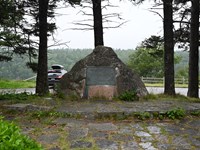 Large pointed rock with plaque on the middle