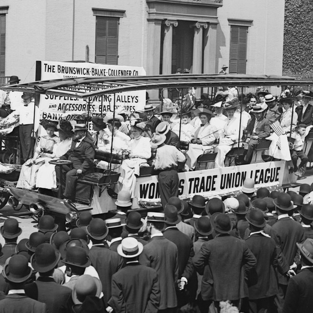 Historic image of wagons with union protesters in a parade