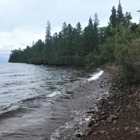 Forest and rocks make of a shoreline along Lake Superior.