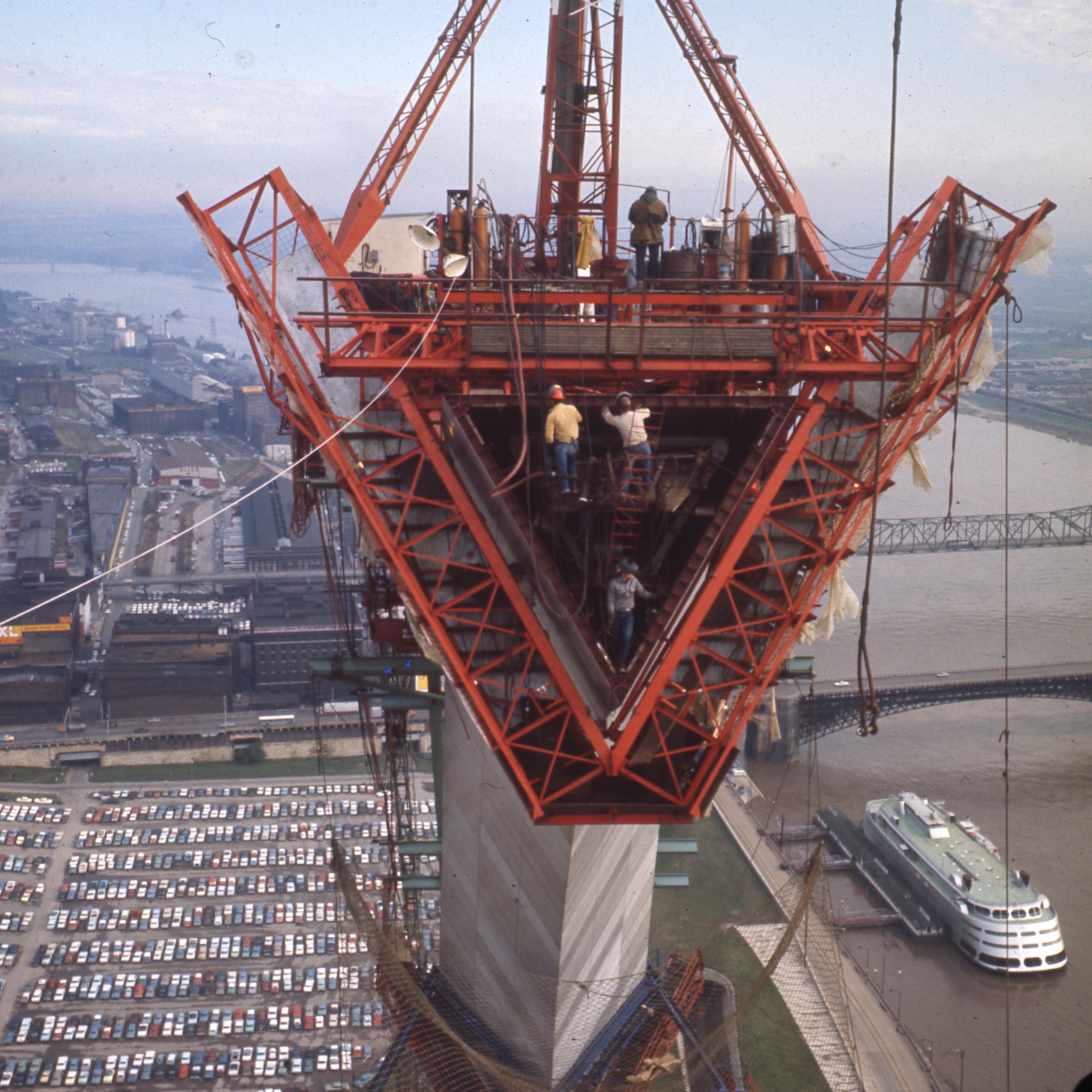 looking into one of the triangle shaped pieces of the Arch from high up, cars and river below