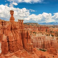 A view over a landscape filled with red rock formations with the iconic thor\'s hammer formation.