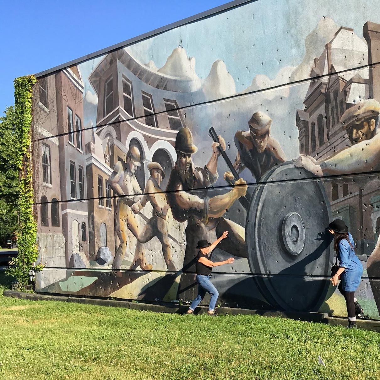 A mural showing Pullman factory workers and Pullman cars