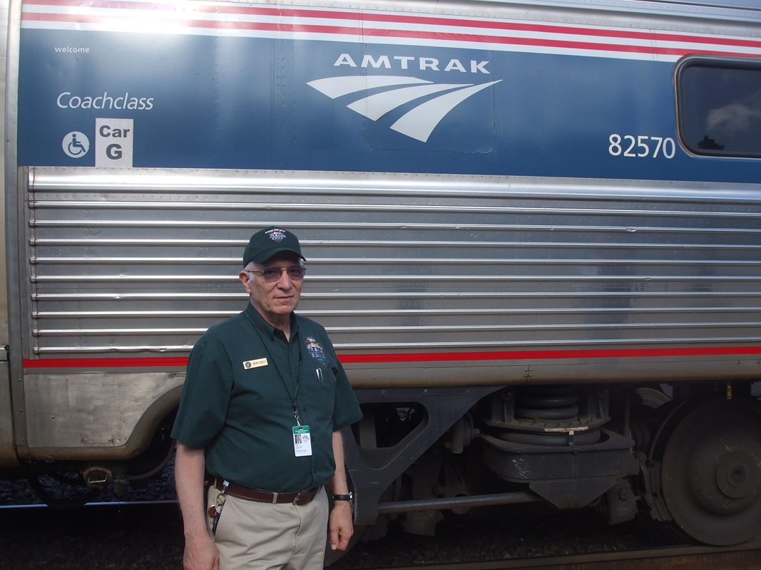 A man stands by an Amtrak train