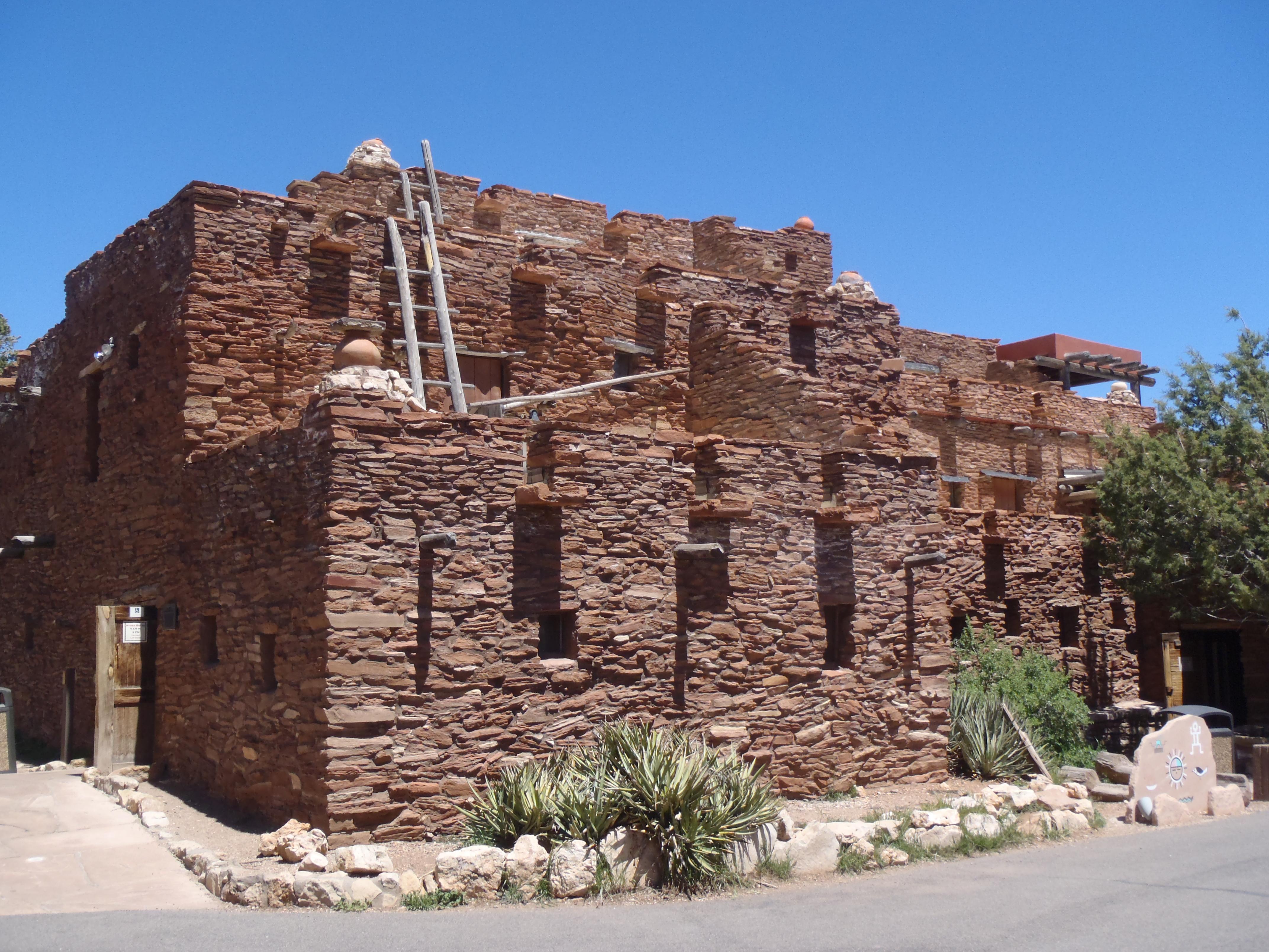 Puebloan-style building, with stone work and wooden ladders.