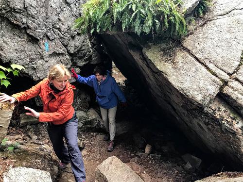 Two hikers navigate a rocky outcropping.