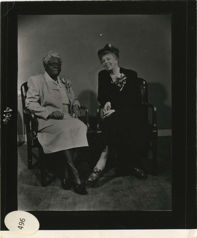 Mary McLeod Bethune and Eleanor Roosevelt sitting next to one another in chairs.