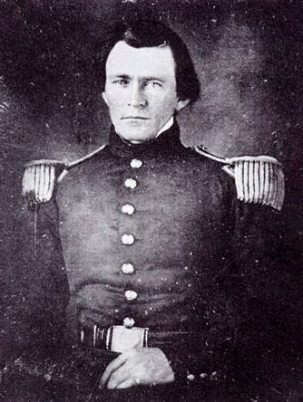 Young man in a dark military uniform with shoulder epaulettes
