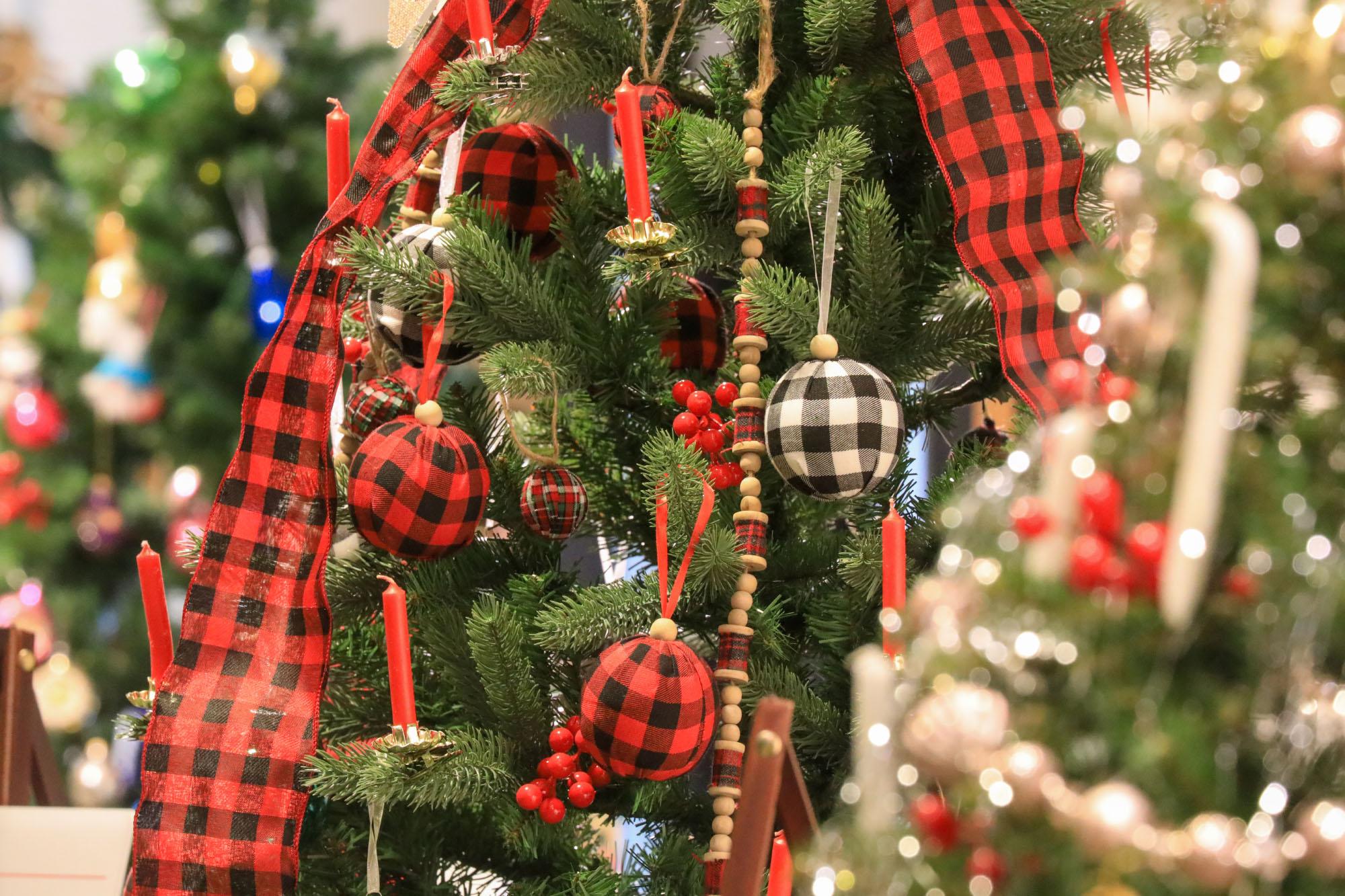 Close up photo of cultural decorations on a Christmas tree. More trees are visible in front and back