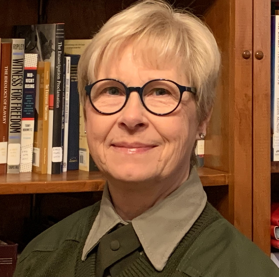 Woman in uniform in from of bookcase