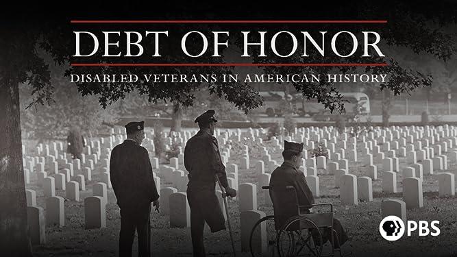 Three soldiers, in front of Veterans' grave markers in a National Cemetery