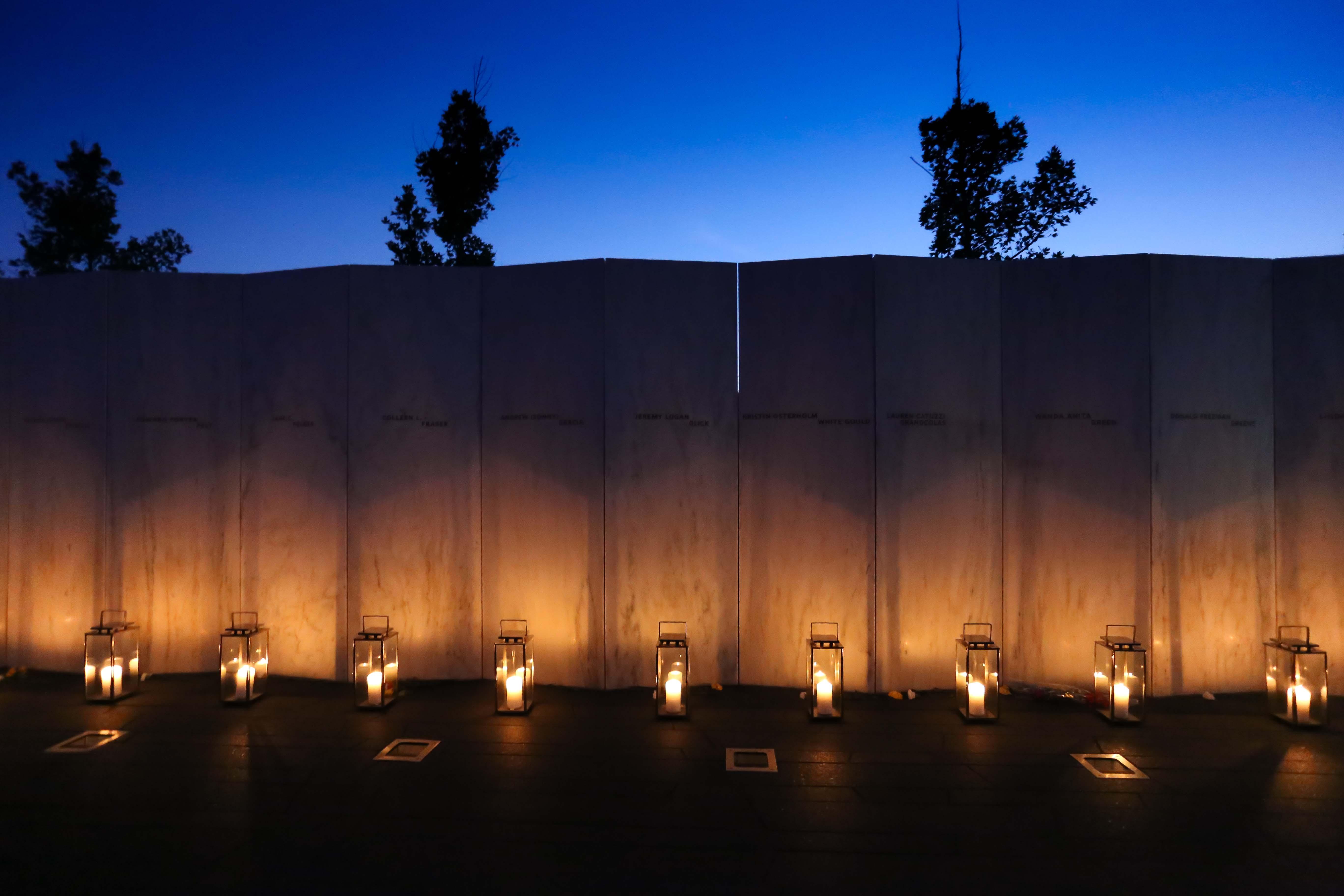 Candle lanterns sitting in front of the Wall of Names.