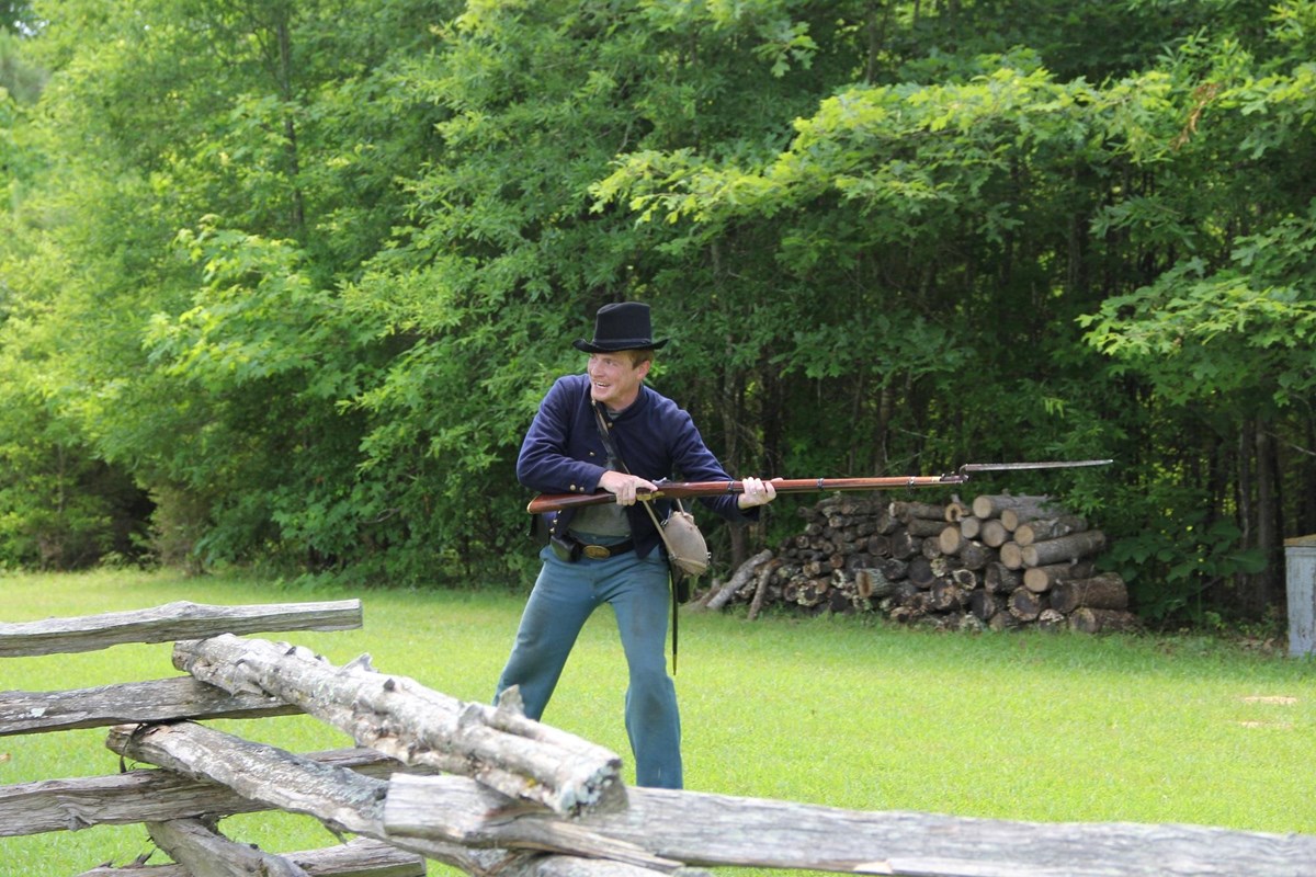 Living historian in blue uniform demonstrates bayonet drill