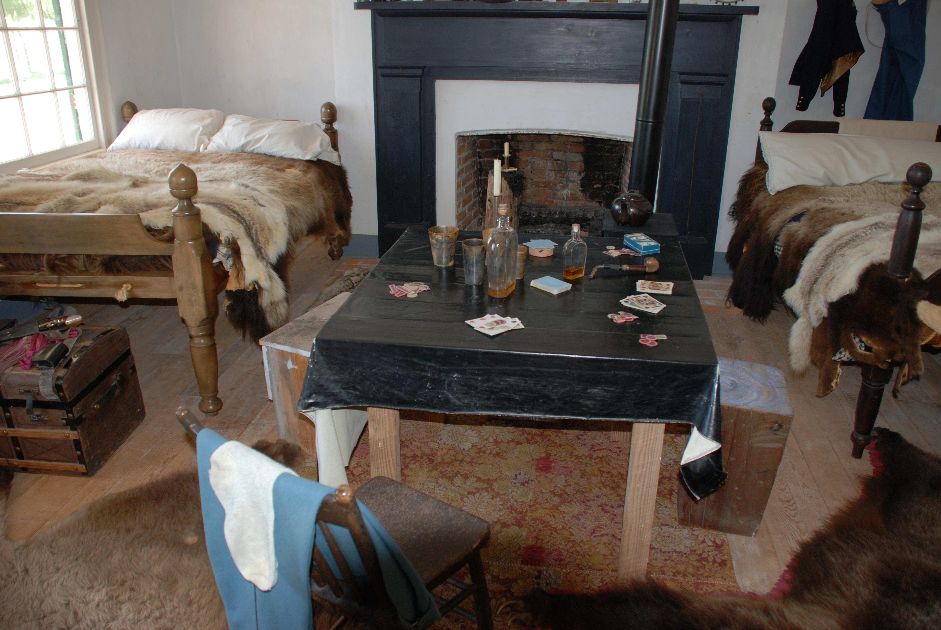 Historic furnishings of the 1850s including buffalo and bear skin blankets in a small room.