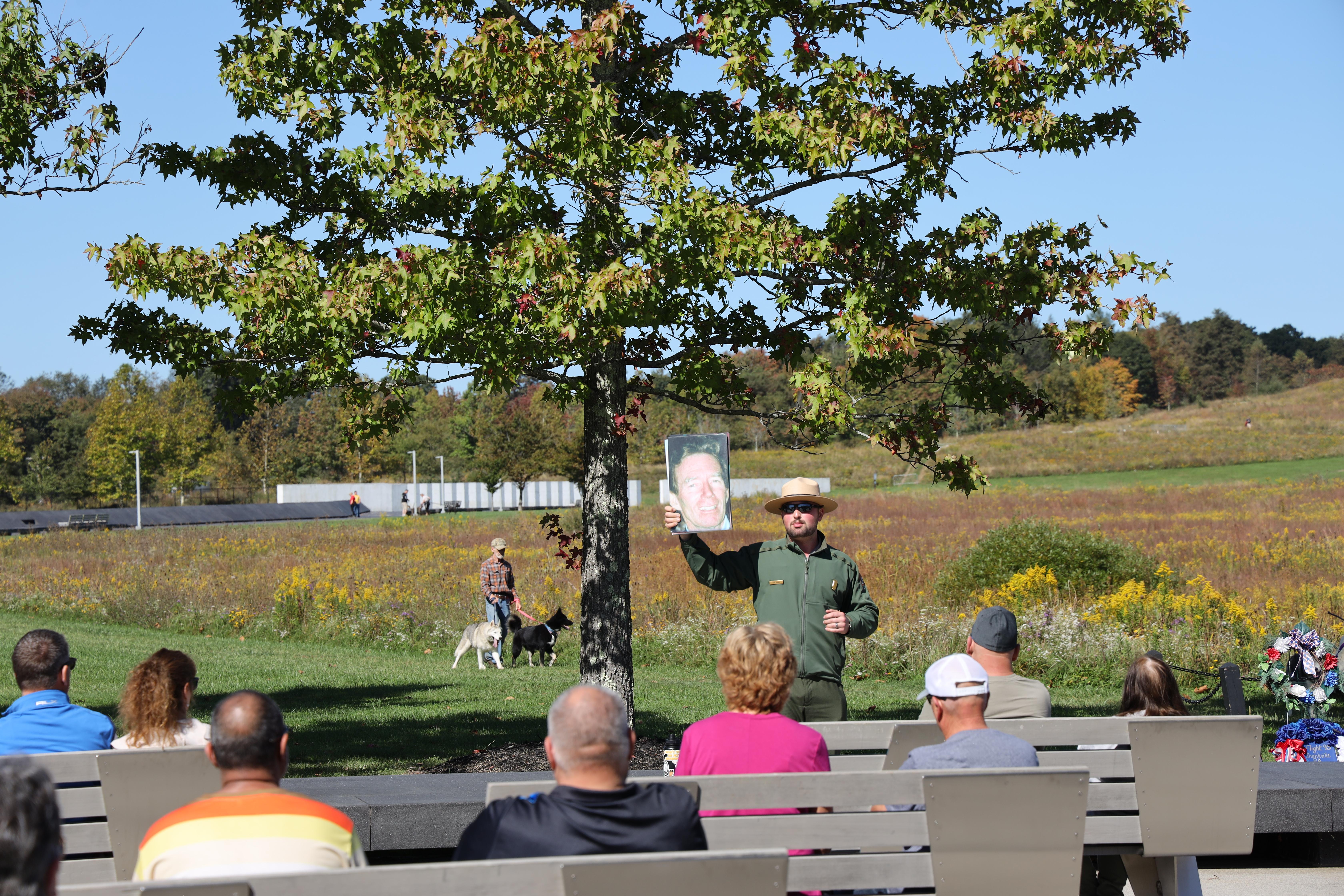 A ranger holding a picture up as the audience watches.