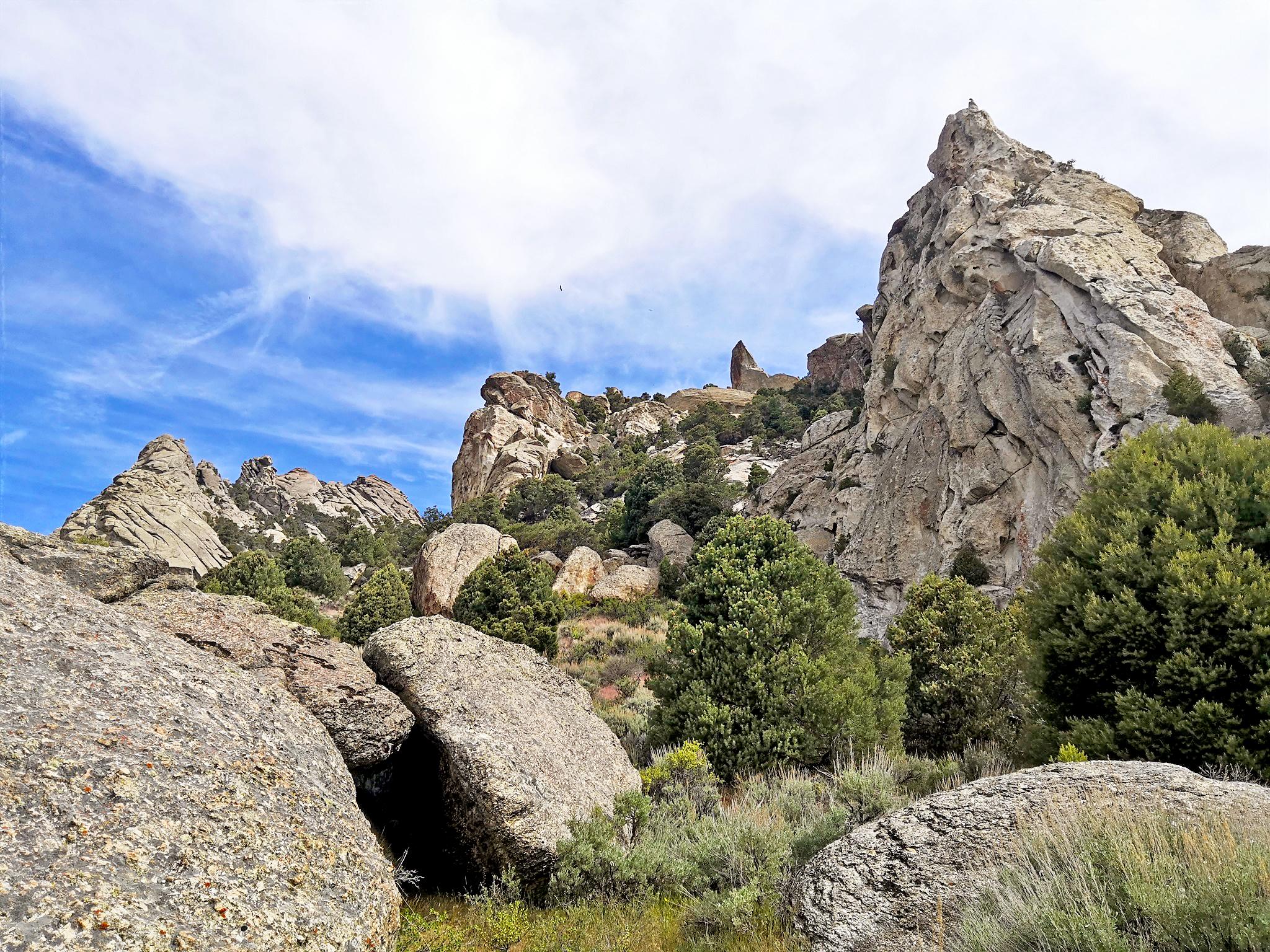 Granite spires and large boulders amidst pinyon, juniper, and brush.