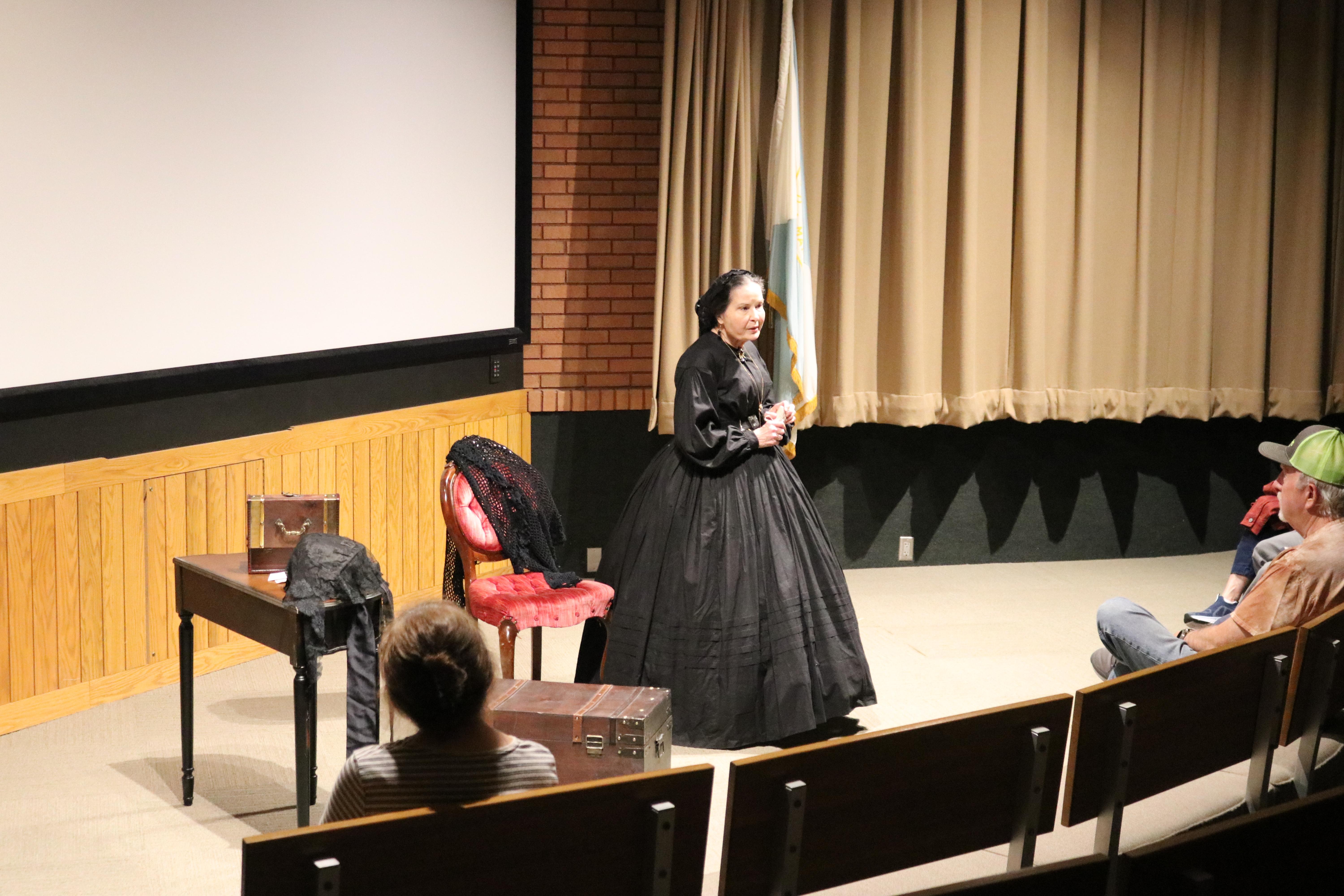 An actor portraying Mary Lincoln stands on stage