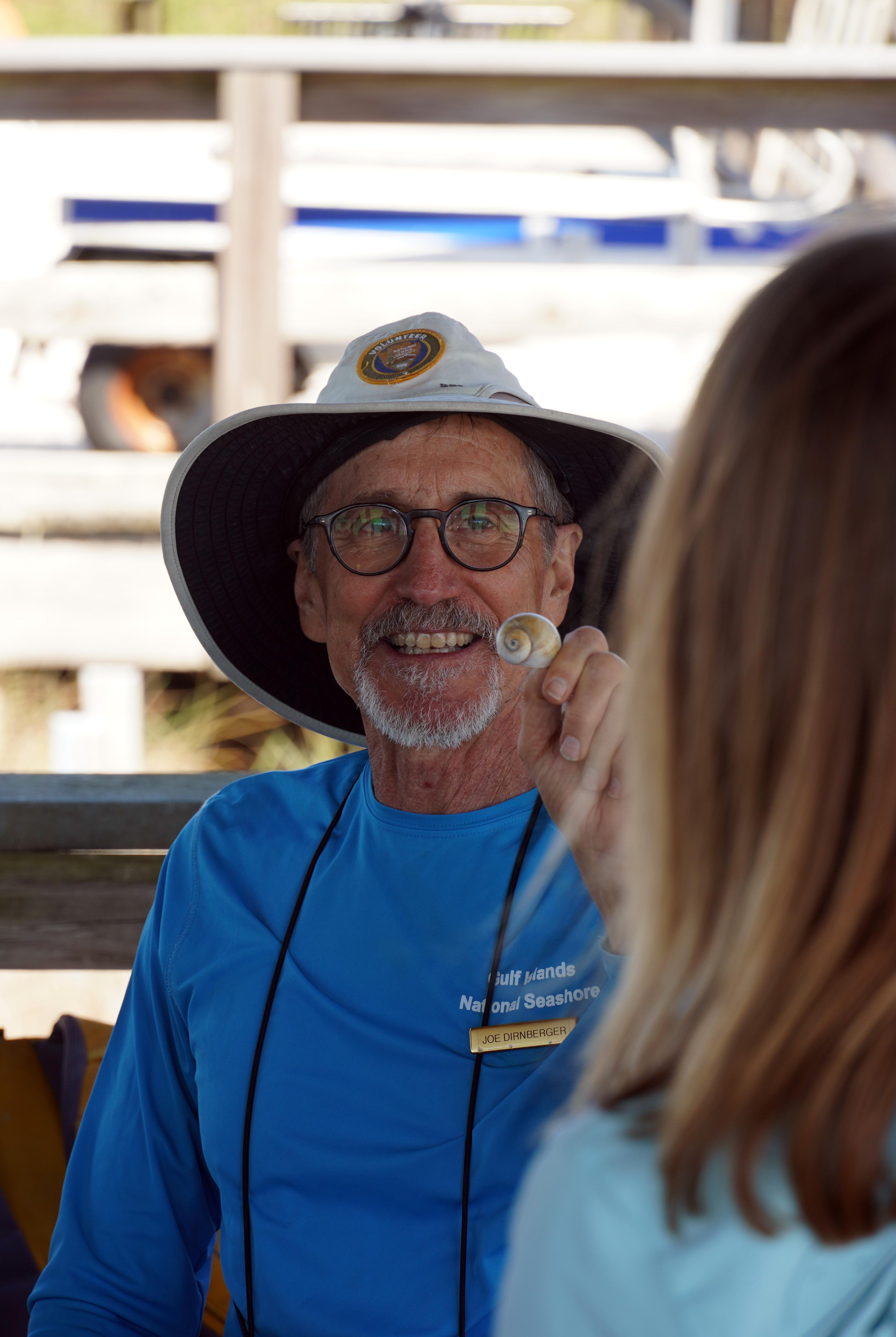 Person holds up a seashell