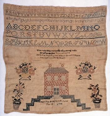 Piece of needlework with alphabet, numbers, house, and flowers