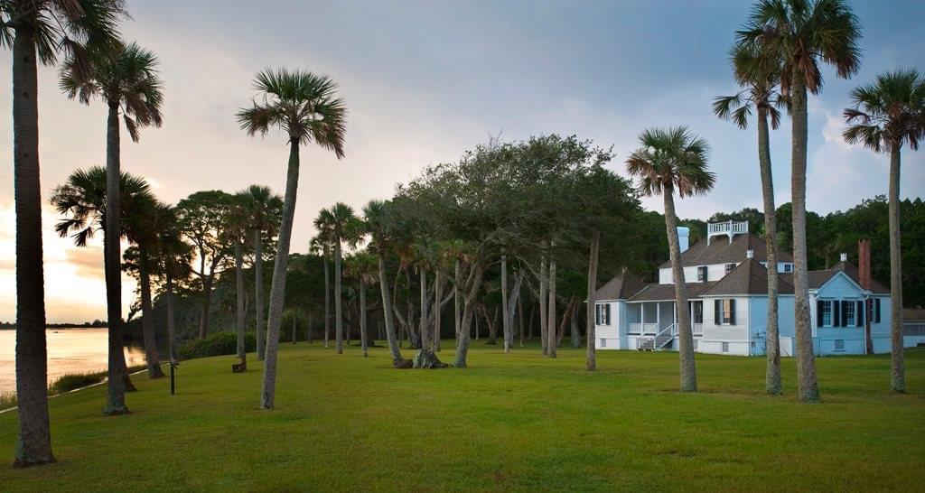 two story white historic building with palm trees