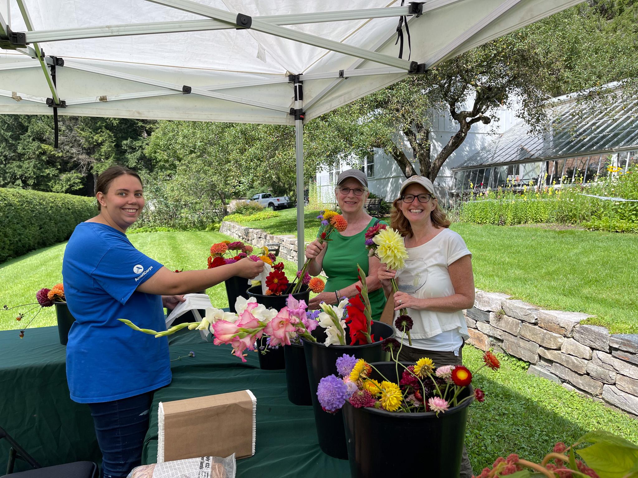 park staff member helps visitors build flower bouquets outdoors
