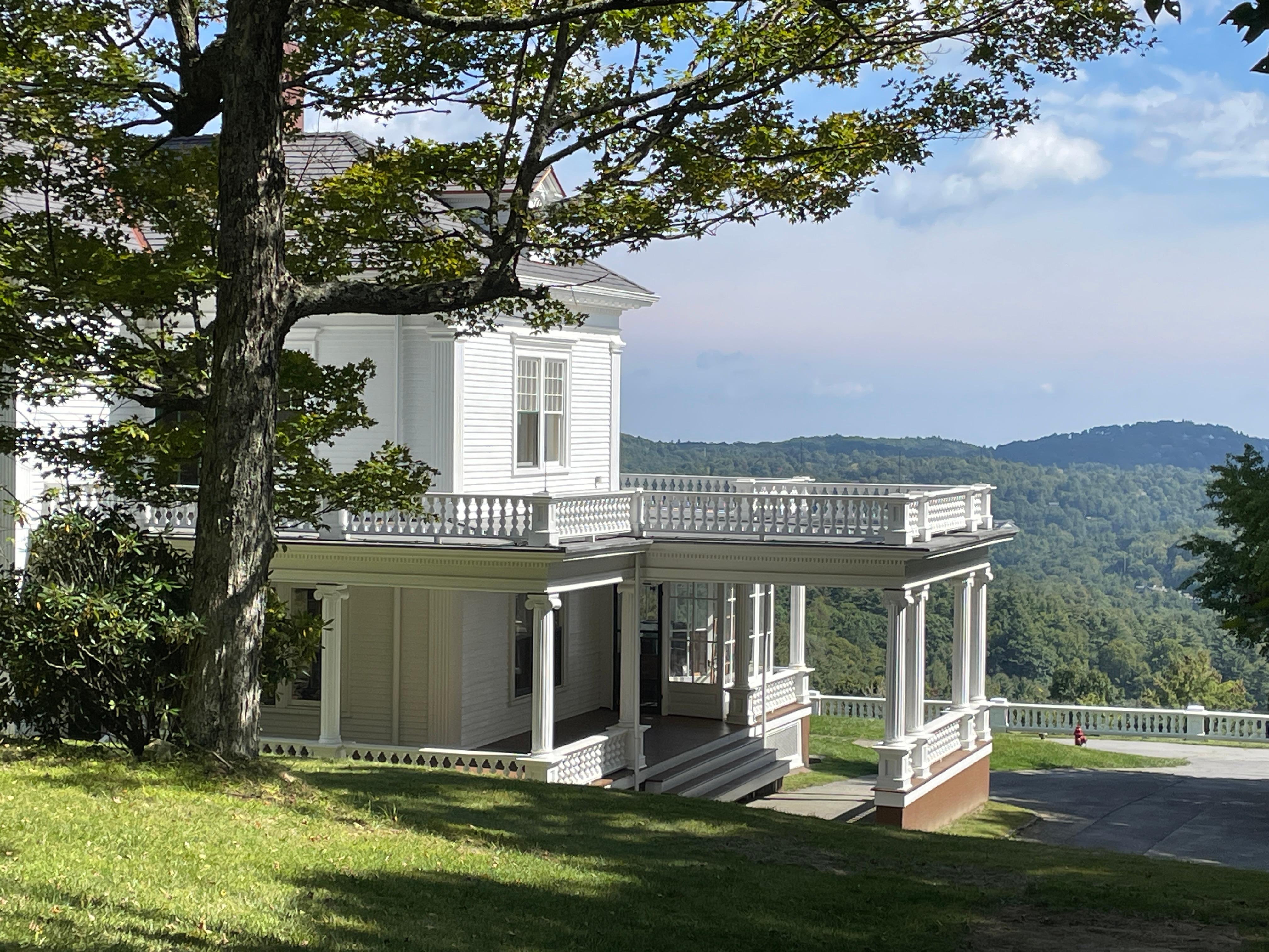 Exterior of Flat Top Manor. A white wooden 4 story mansion with expansive views of the mountains.
