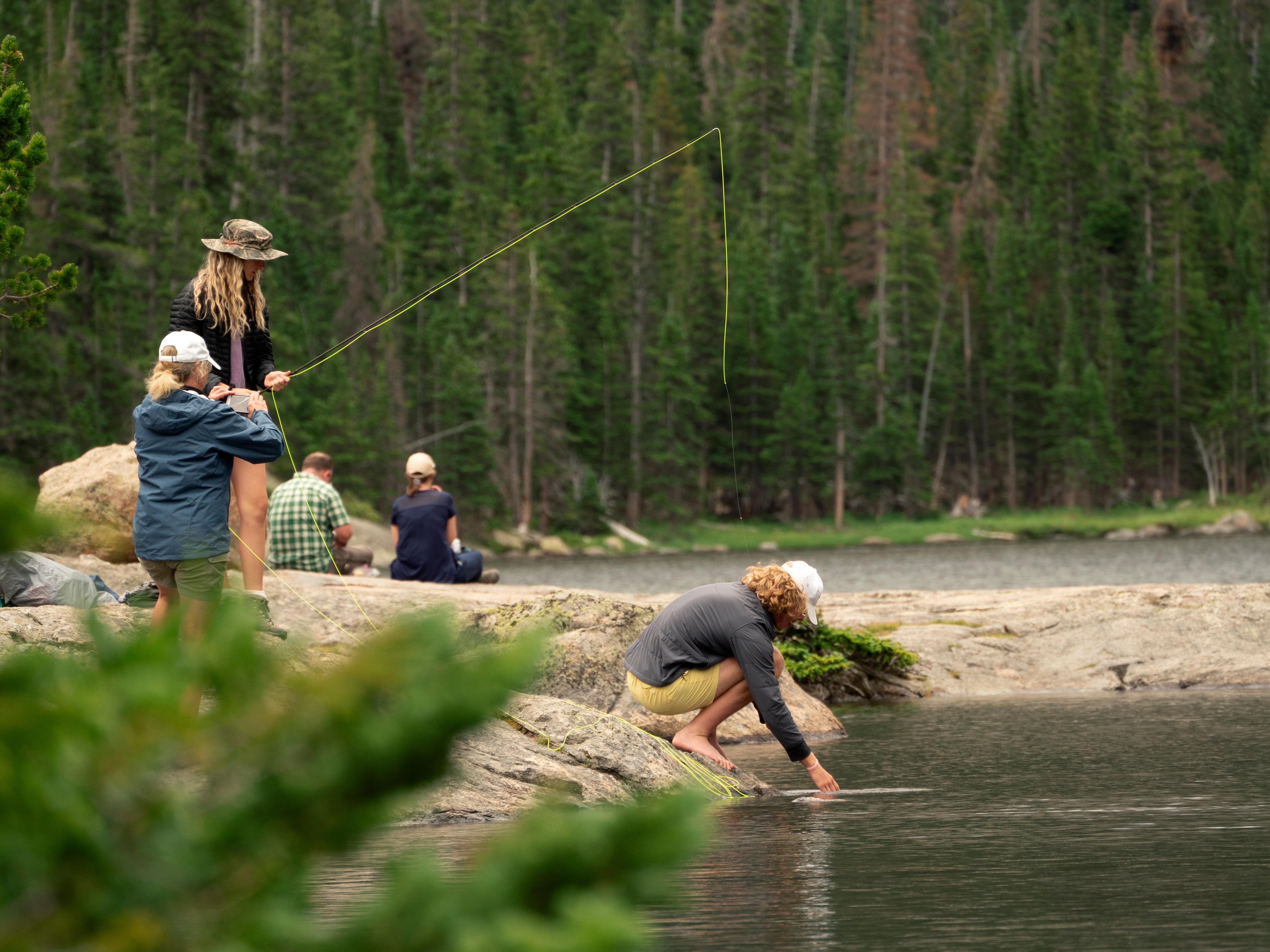 A visitor is fishing on the shore of Mills Lake