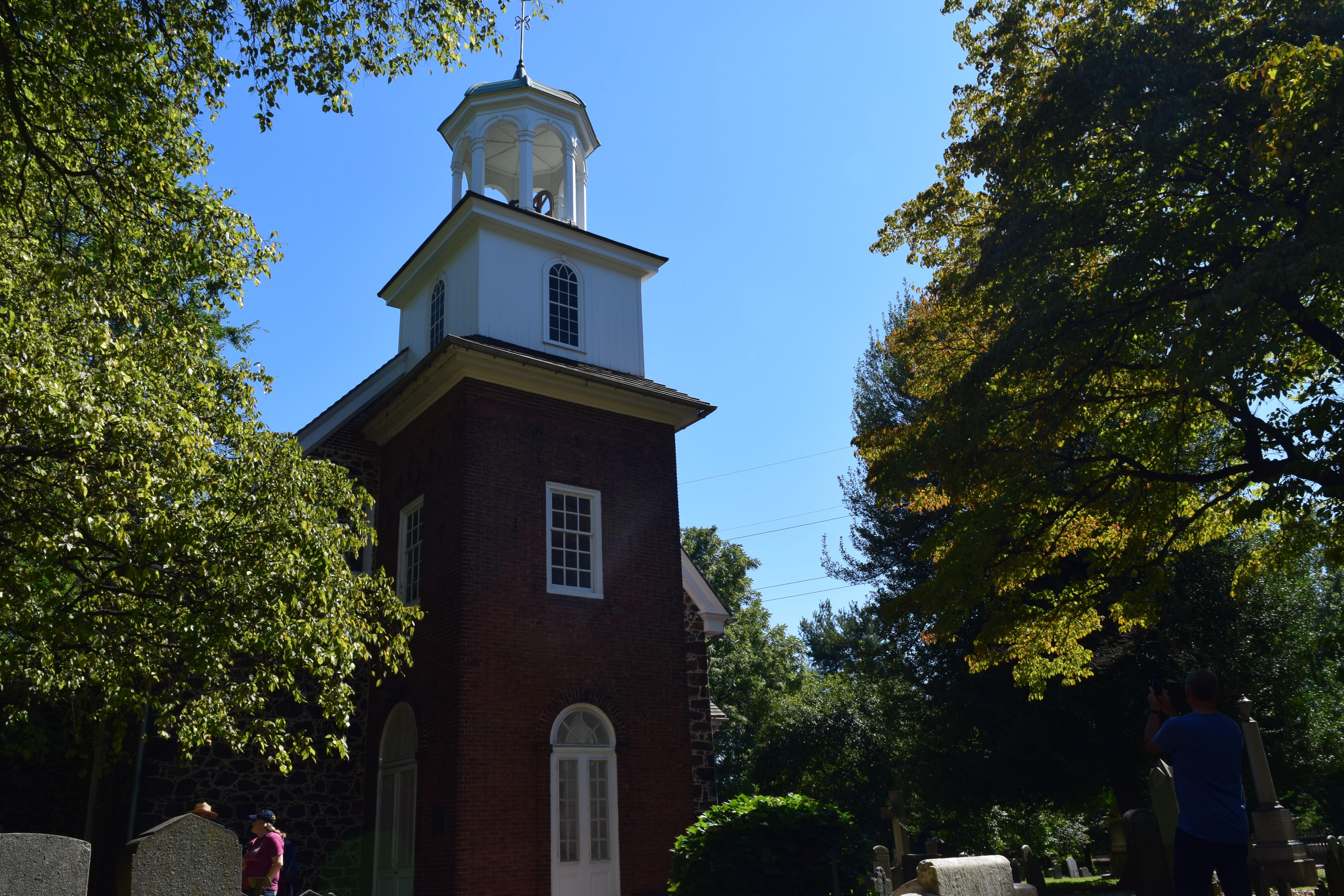 A brick church with a white cupola on top.