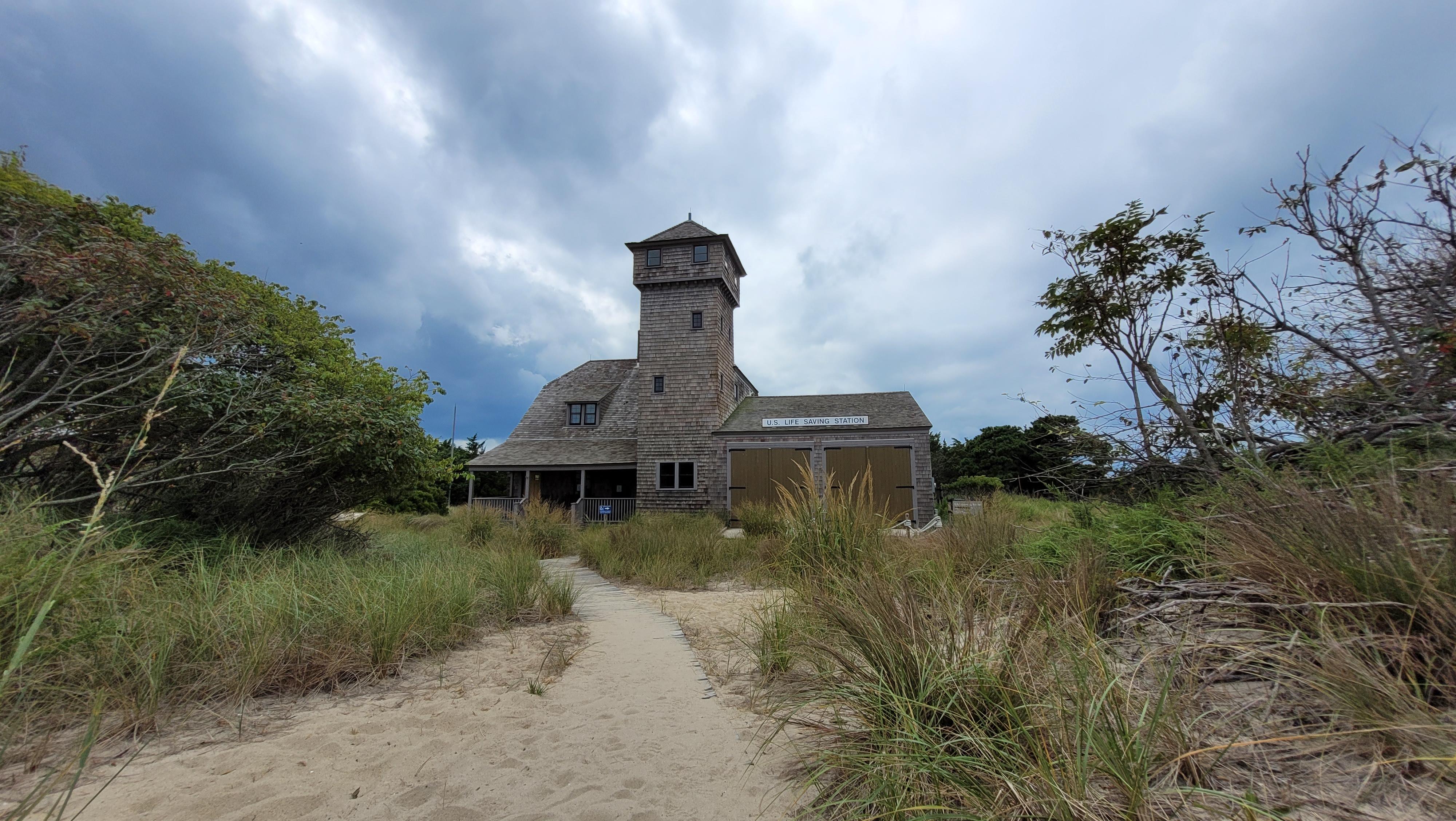 Historic wood shingled building amongst beach vegetation