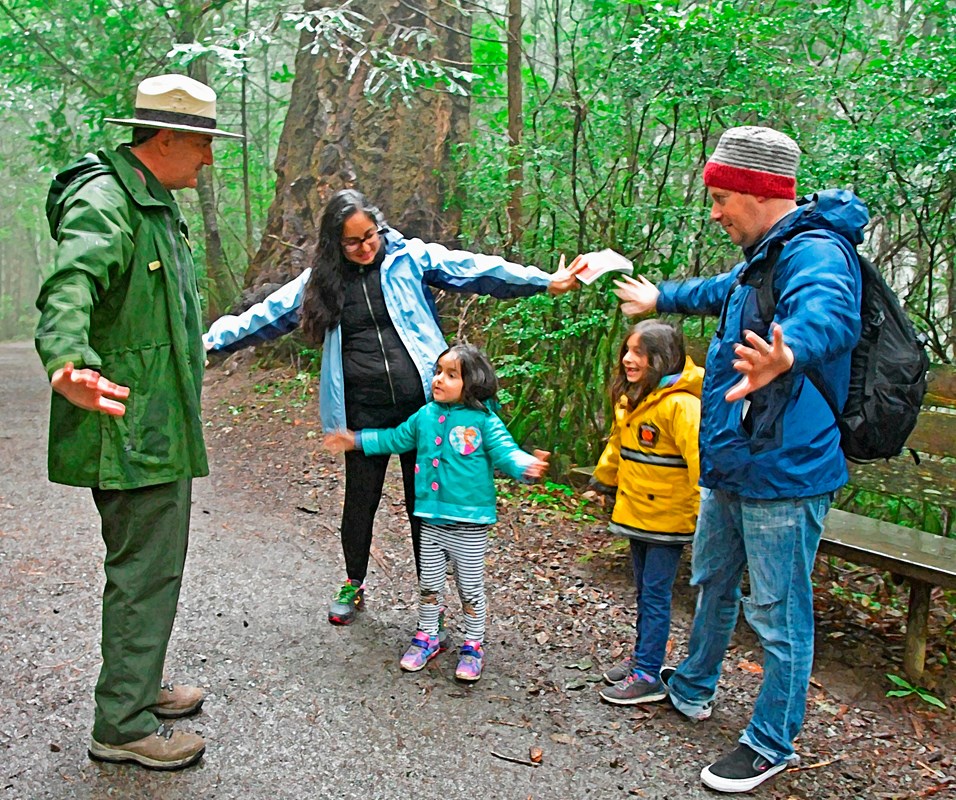 A ranger and park visitors on a trail.