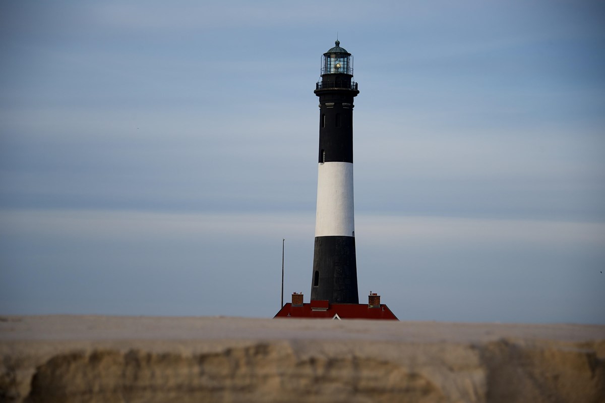 A lighthouse on a white sand beach