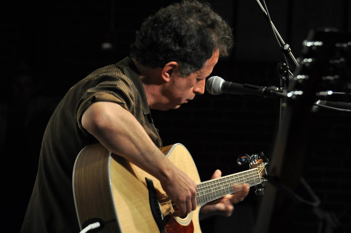 A man playing an acoustic guitar.