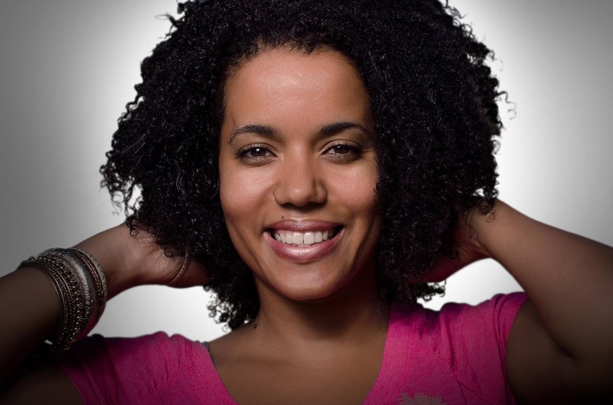 Iva Brito with her hands raised while posing for a profile image.