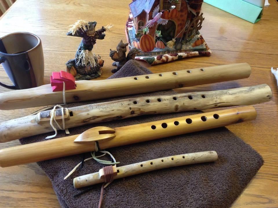 Several wooden flutes rest on a table.