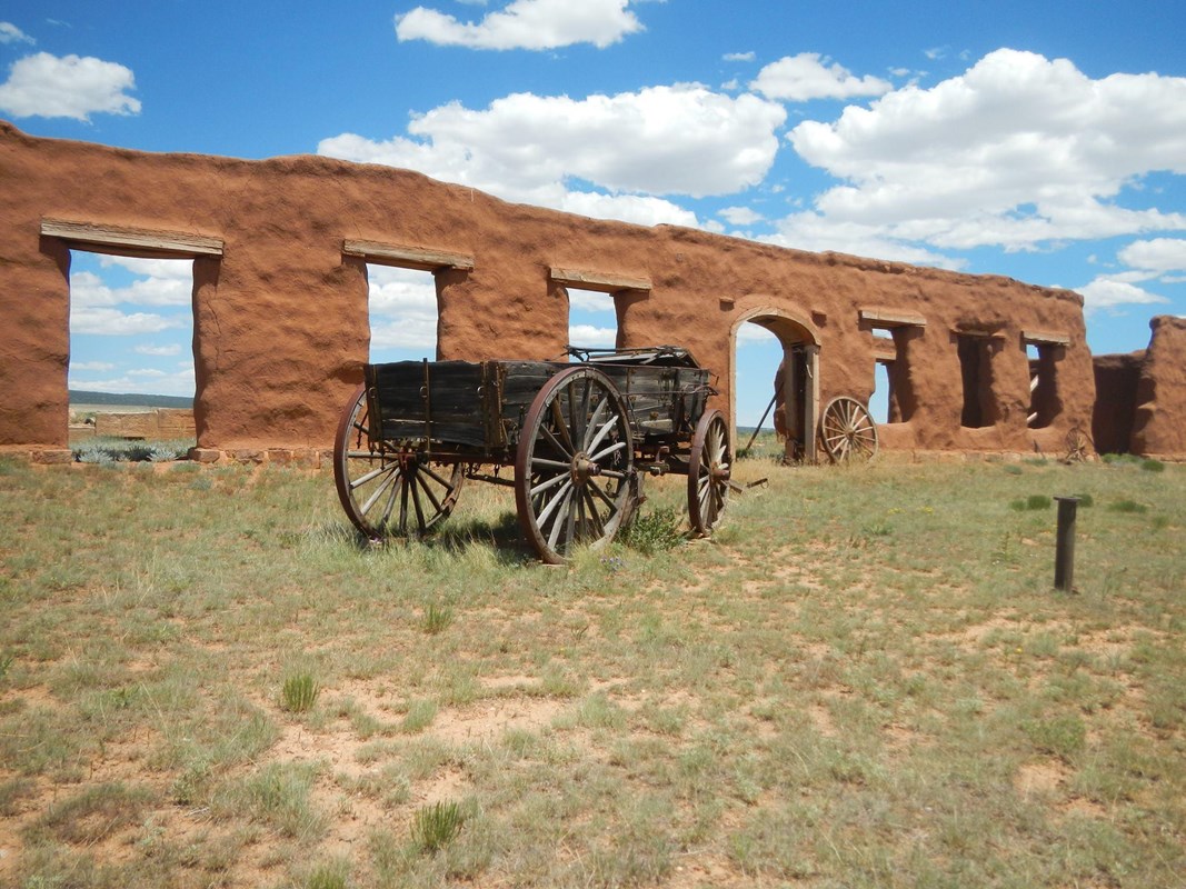Wagons in front of old adobe walls and doorways.