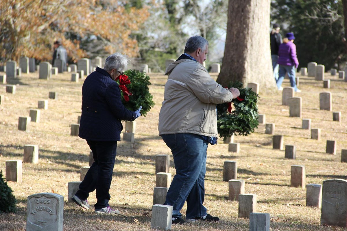Visitors placing wreaths in cemetery