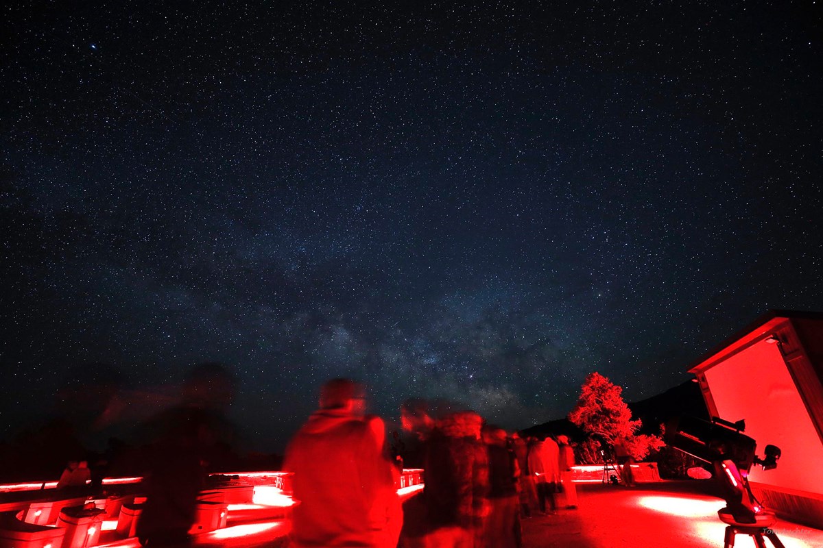 Ranger giving astronomy program under red light.