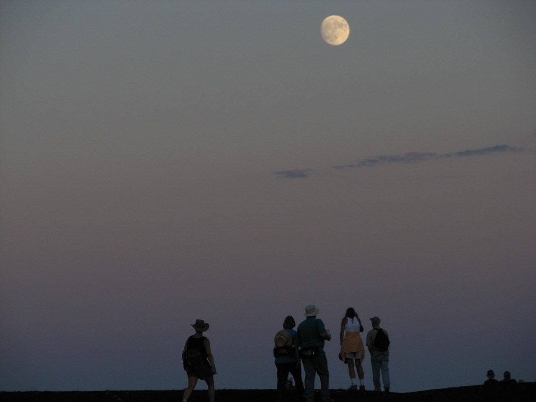 hikers beneath a full moon