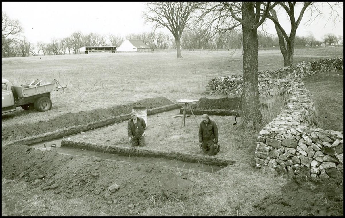 Two men standing in a trench area at the park.