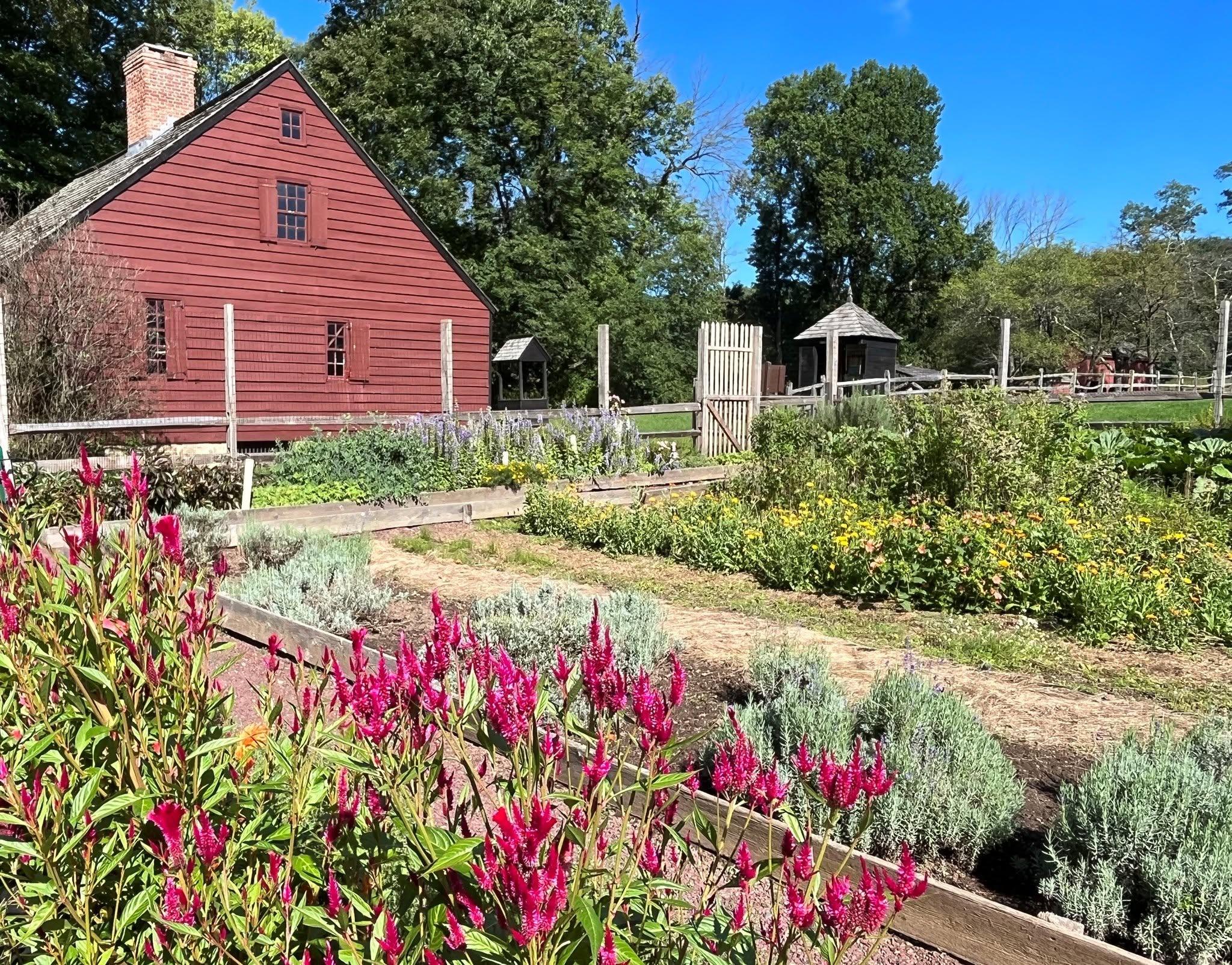A garden in front of a red house.